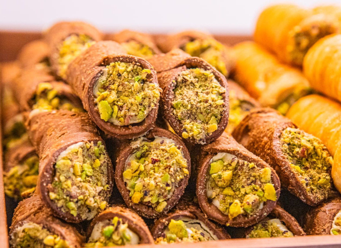 A pile of pistachio-finished chocolate cannoli at Adore Bakery