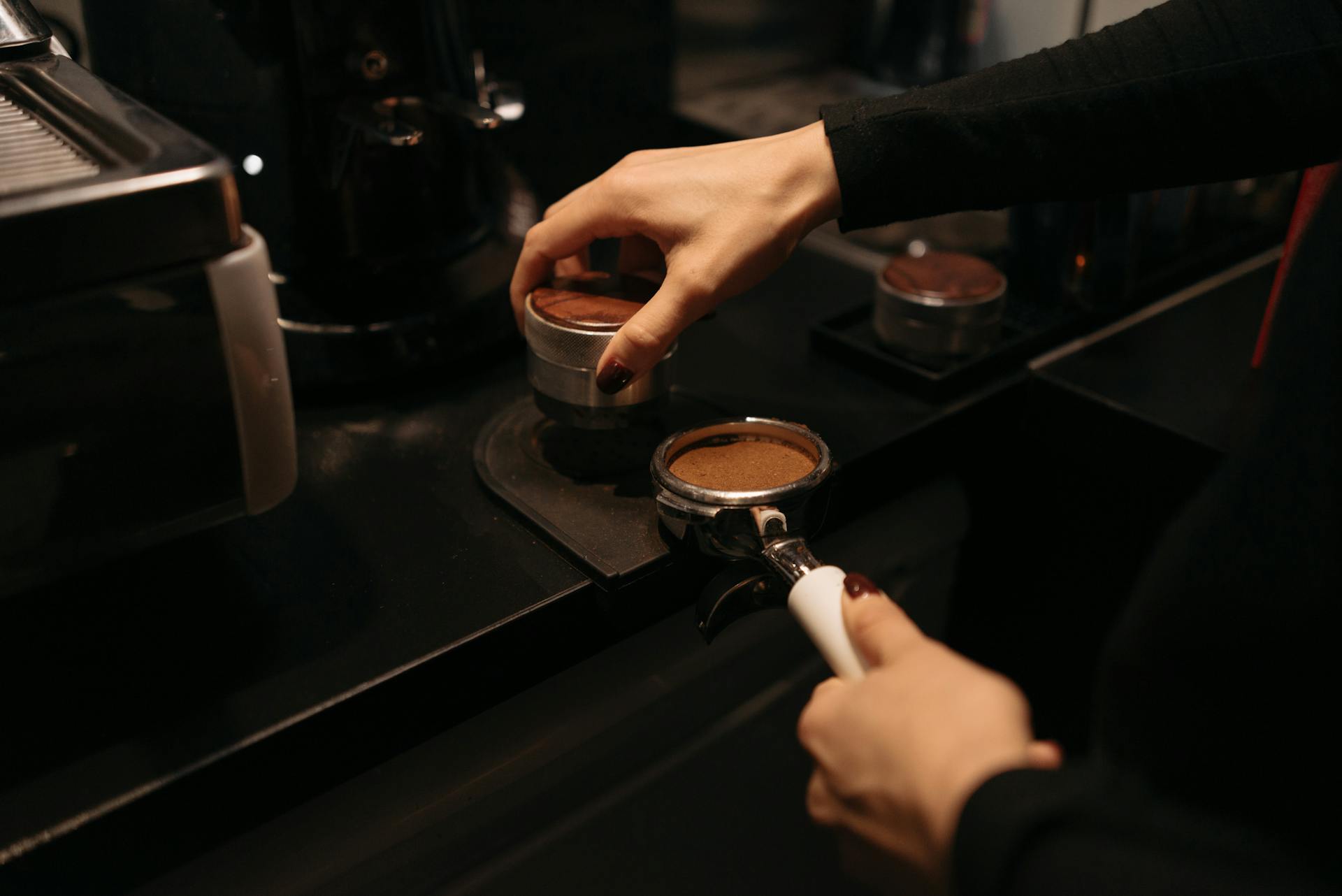 Barista hands tamping espresso, close-up