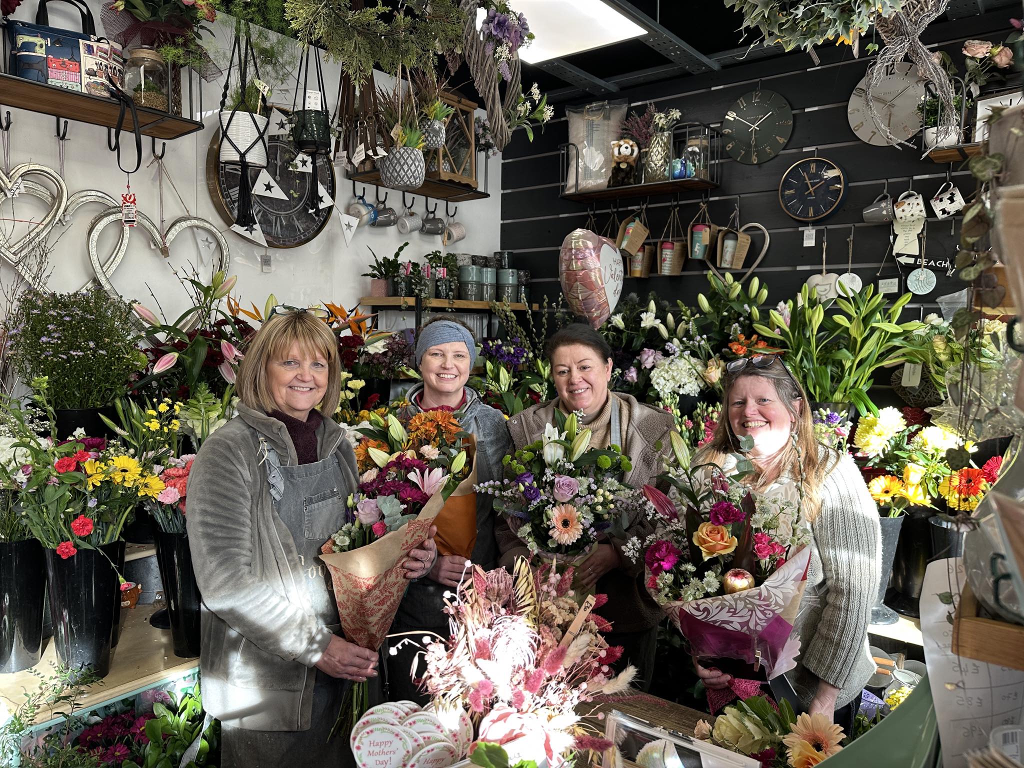 The Googie's team in the shop holding hand-tied bouquets