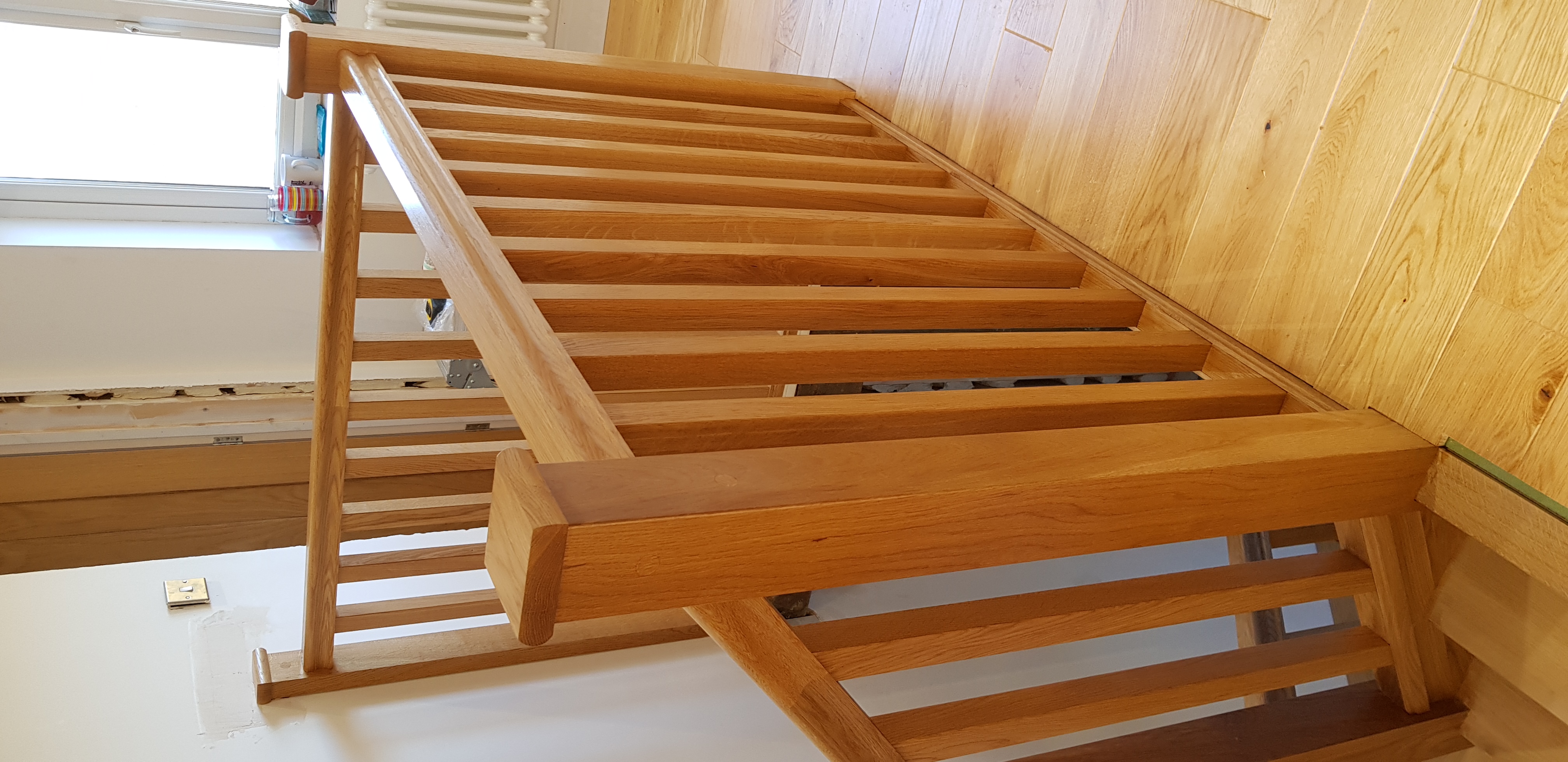 A refinished light-oak chair detail — slatted back and turned legs, by JD Furniture Restoration