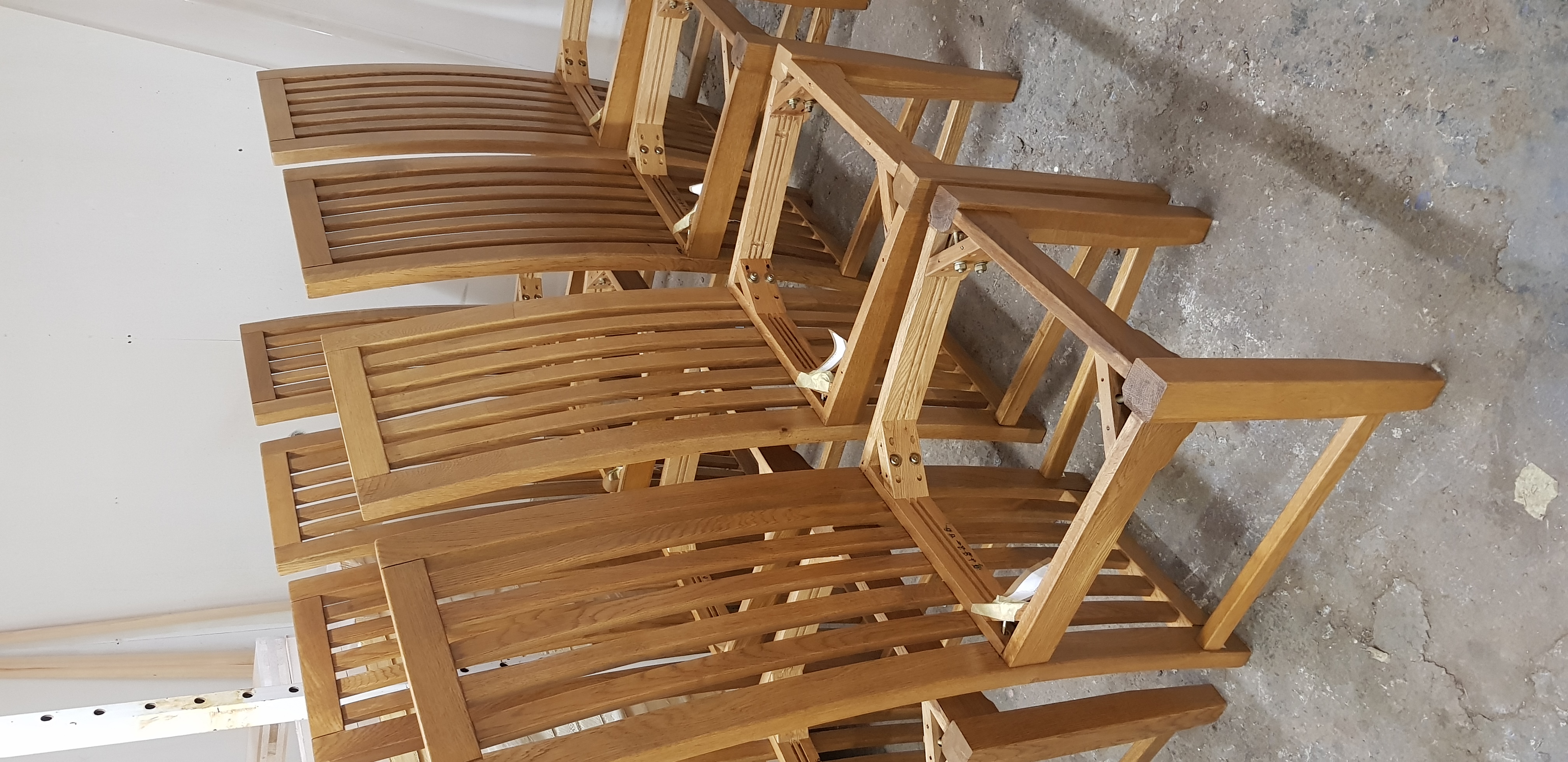 A solid oak slatted bench restored by JD Furniture Restoration in a wood-panelled hallway