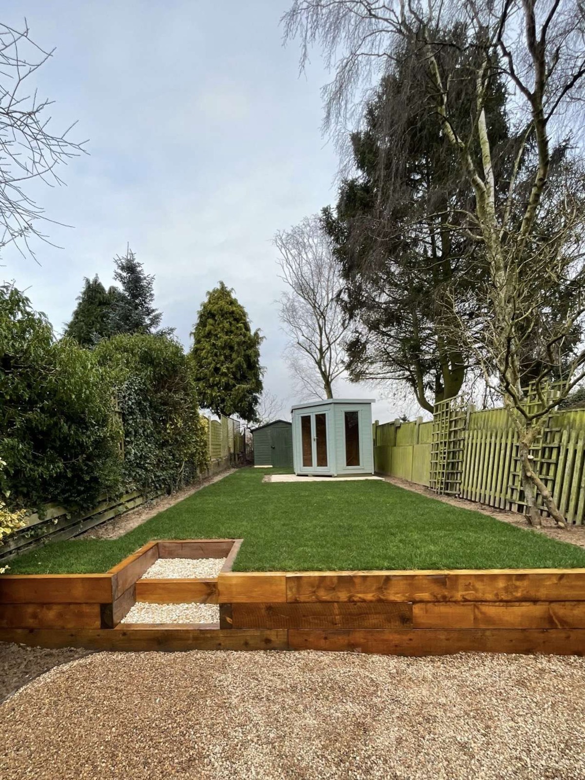 Complete garden transformation by Lazy Days — new lawn, timber sleeper wall and steps, summerhouse base, shed base and horizontal slatted fence