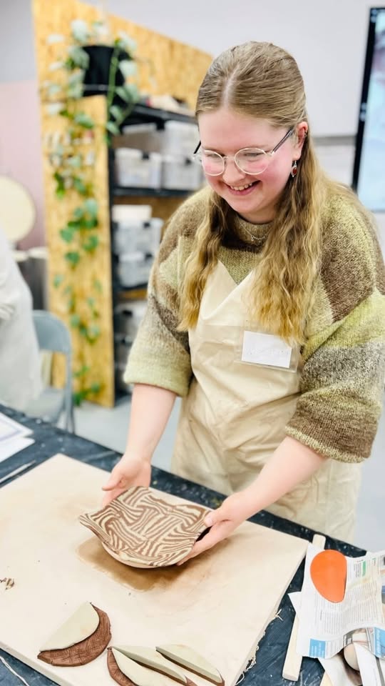 Hands shaping clay on a pottery wheel at Norwich Pottery Studio